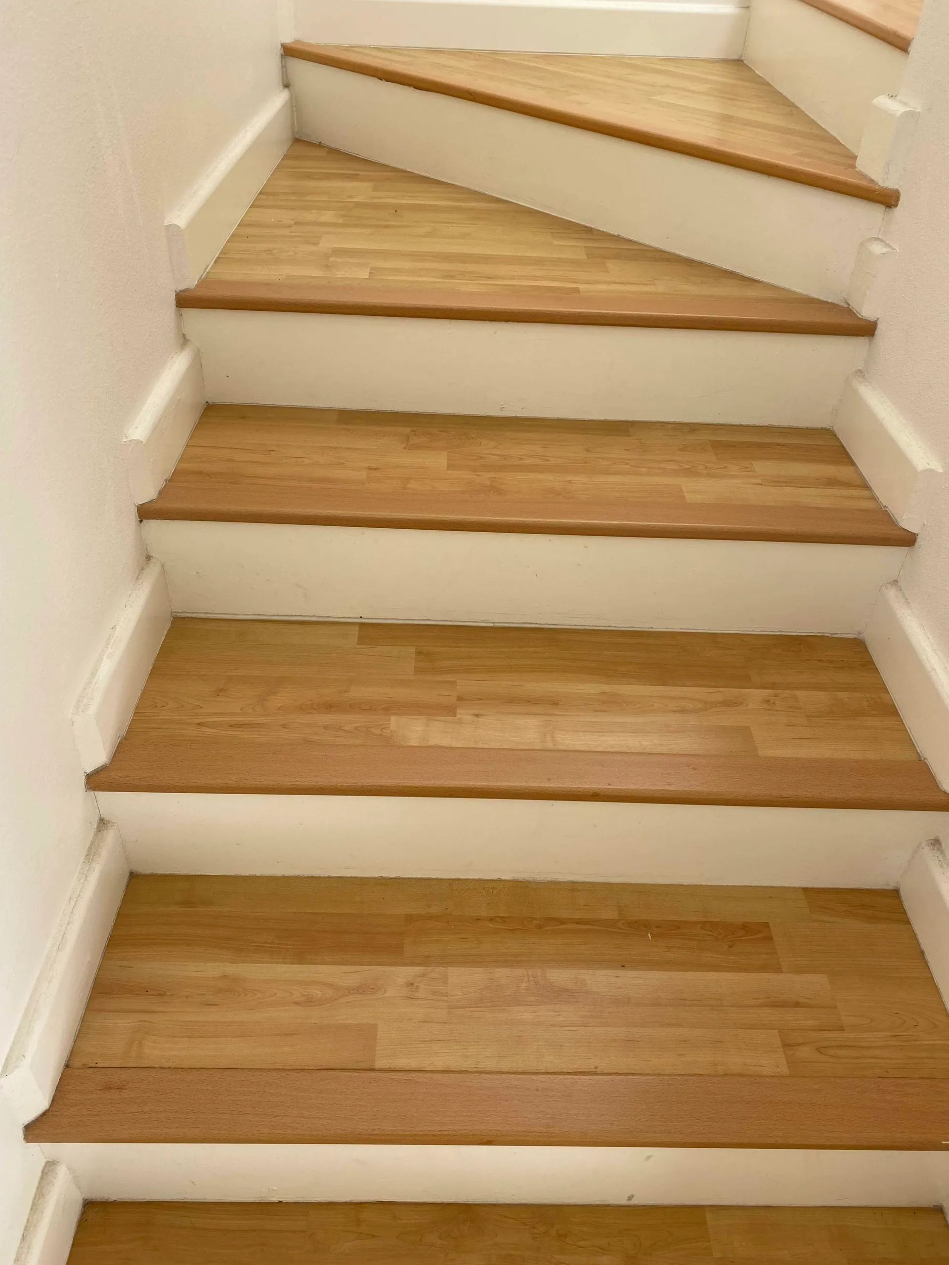 A set of stairs with wooden steps and white risers
