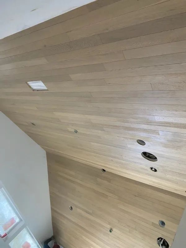 A room with a wooden ceiling and a white wall