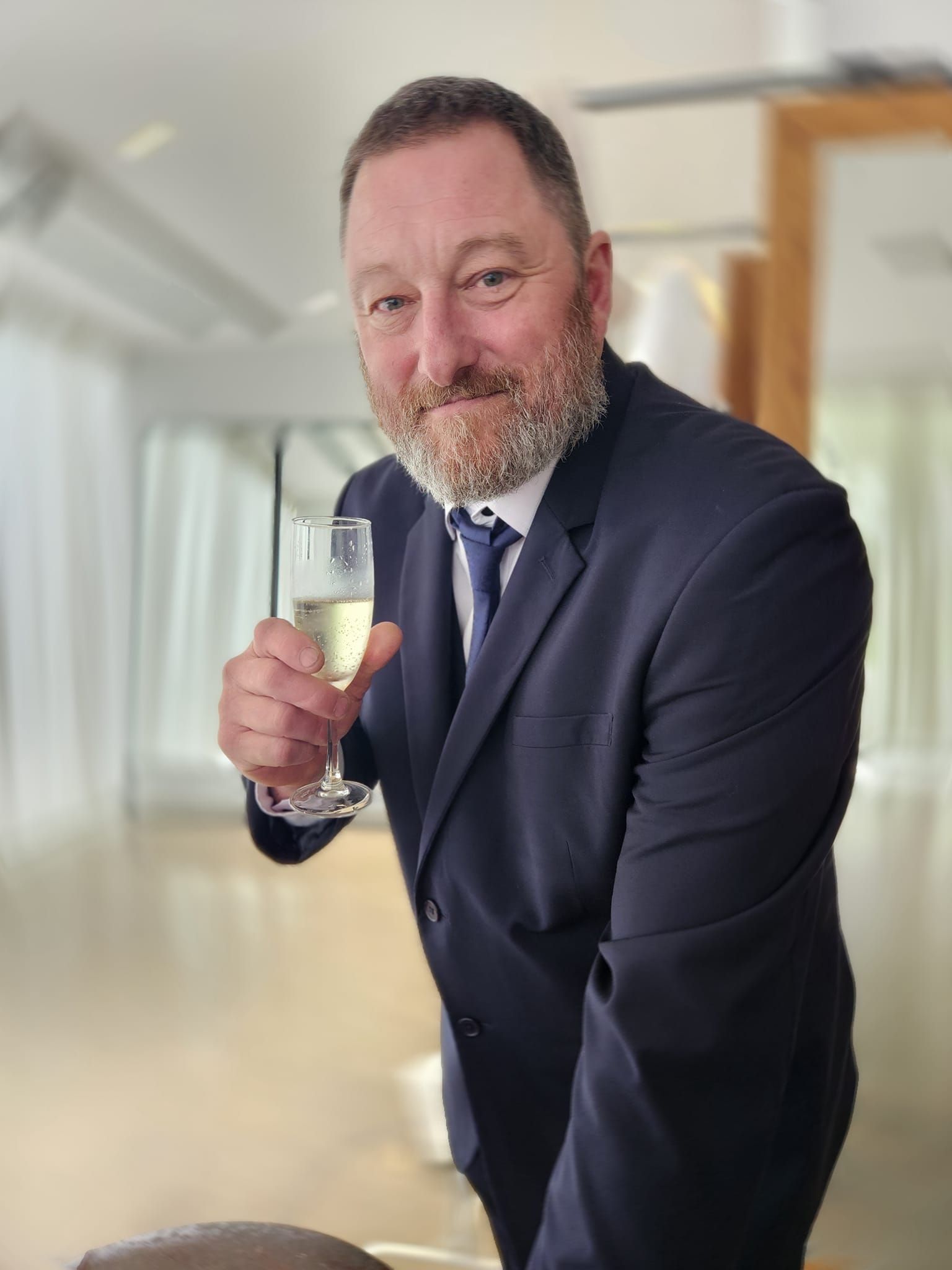 A Man In A Suit And Tie Is Holding A Glass Of Champagne — Sew Affordable In Charmhaven, NSW