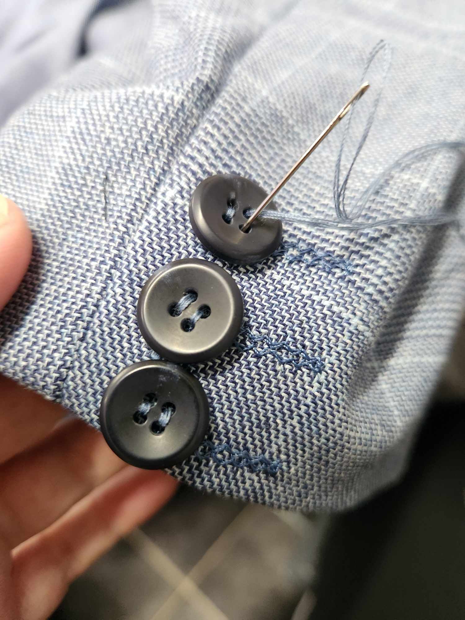 A Button Is Being Sewed On A Blue Jacket — Sew Affordable In Charmhaven, NSW