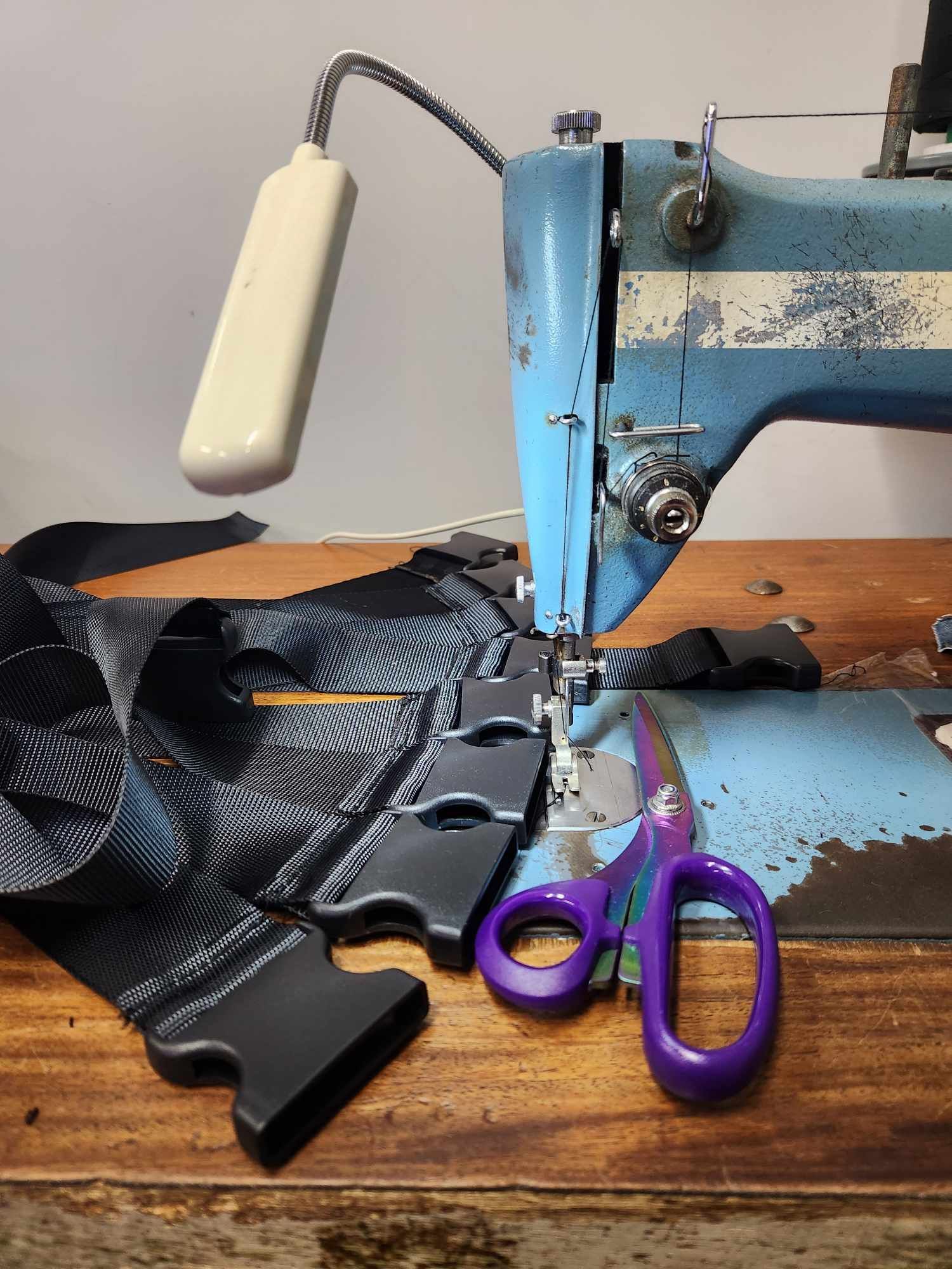 A Sewing Machine Is Sewing Buckles On Black Straps— Sew Affordable In Charmhaven, NSW