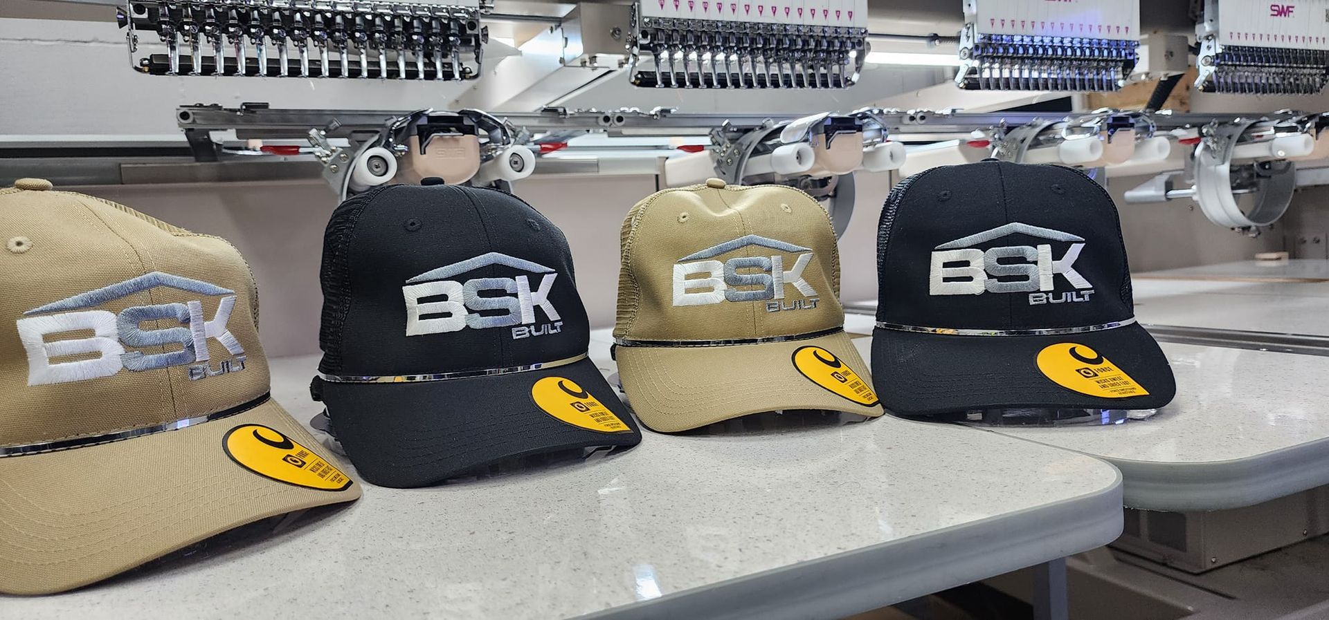 Four Baseball Caps With BSK Logo Embroidery on A Table — Sew Affordable In Tuggerah, NSW