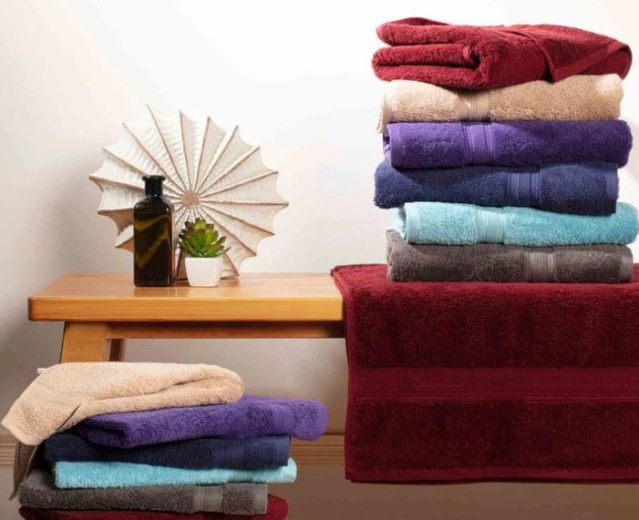 A Shelf Filled With Stacks Of Towels Of Different Colors — Sew Affordable In Charmhaven, NSW