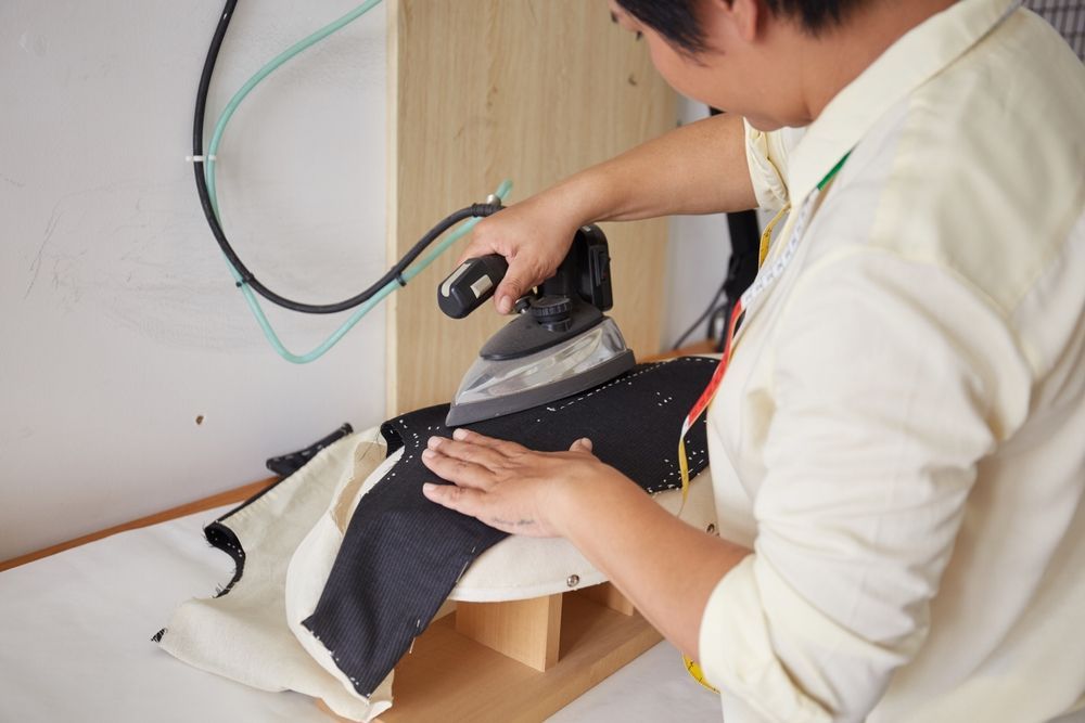 A Man Is Using A Heat Press Machine To Print A T-shirt — Sew Affordable In Charmhaven, NSW
