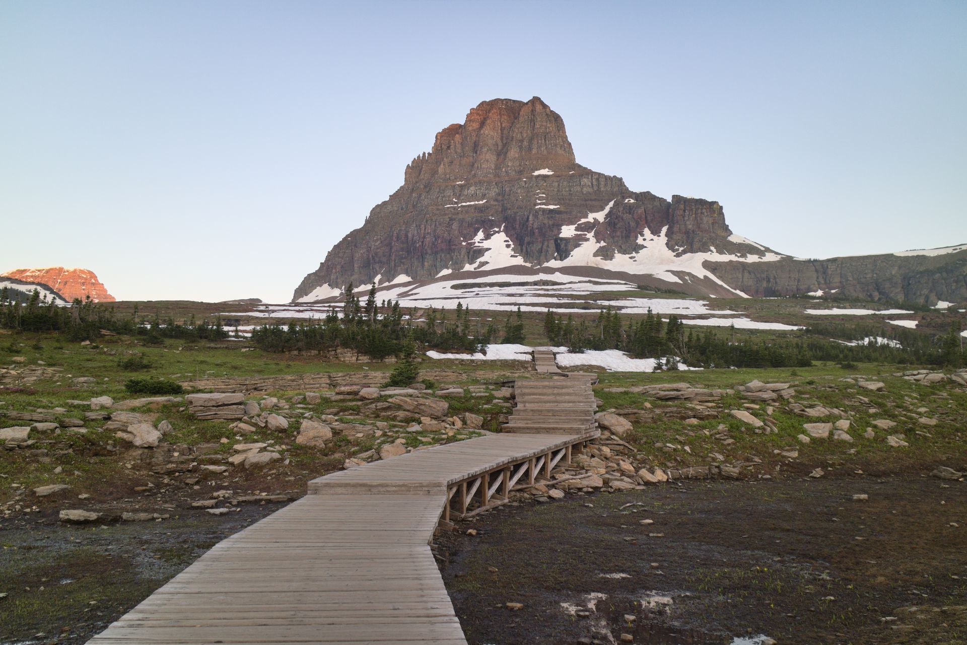 A wooden walkway leading to a mountain in the distance