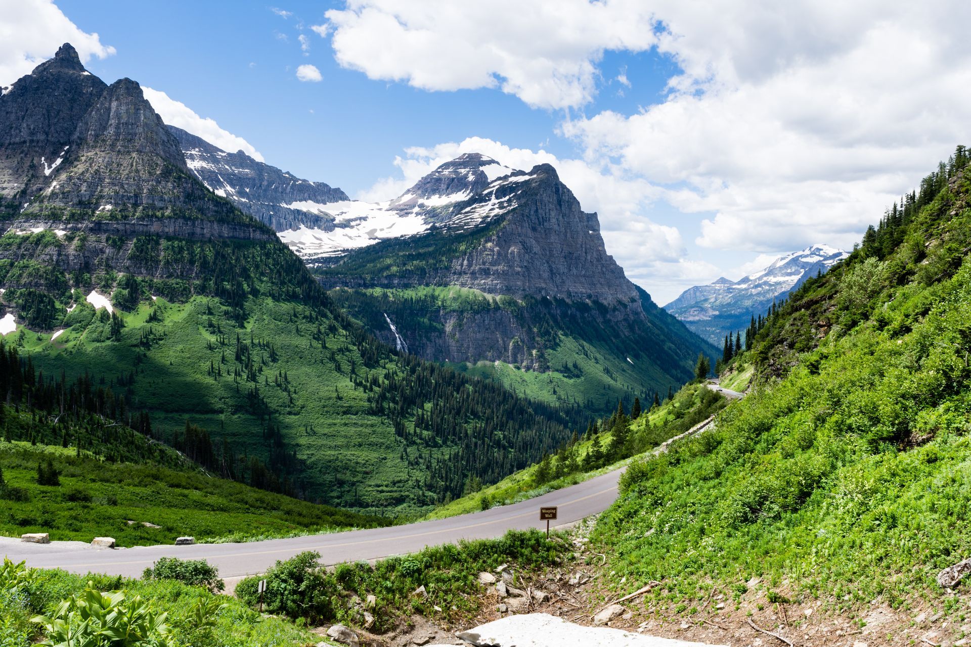 A road going through a valley with mountains in the background