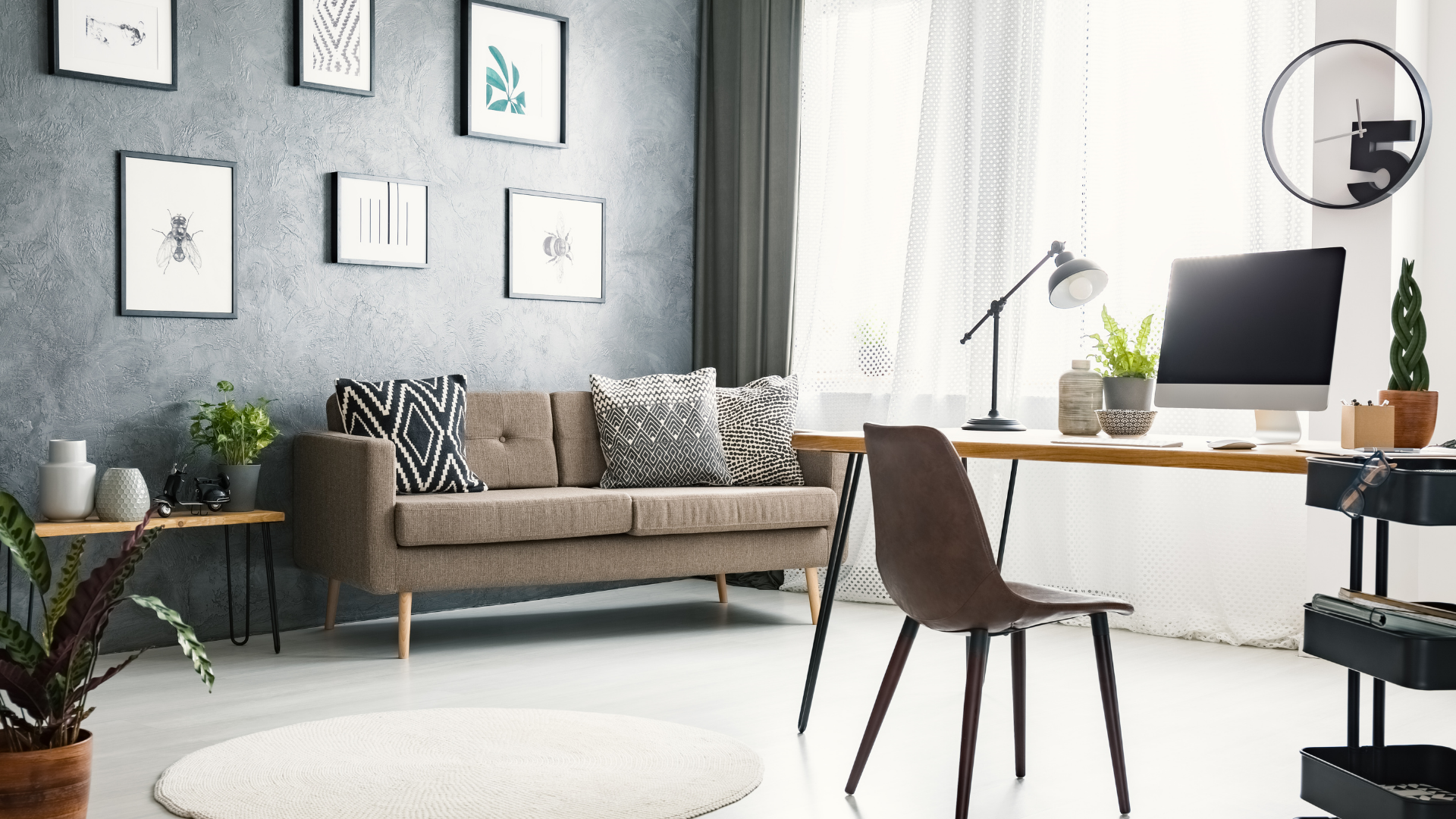 A living room with a couch , desk , chair and computer.