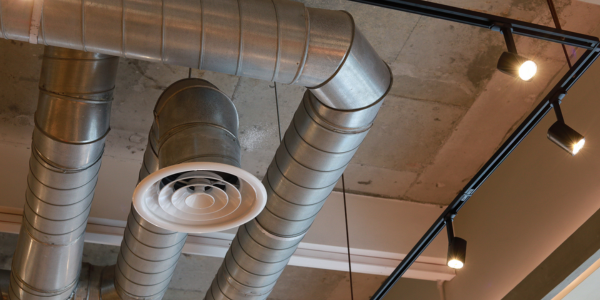 A bunch of metal pipes are hanging from the ceiling of a building.