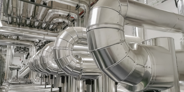 A row of stainless steel pipes in a factory.