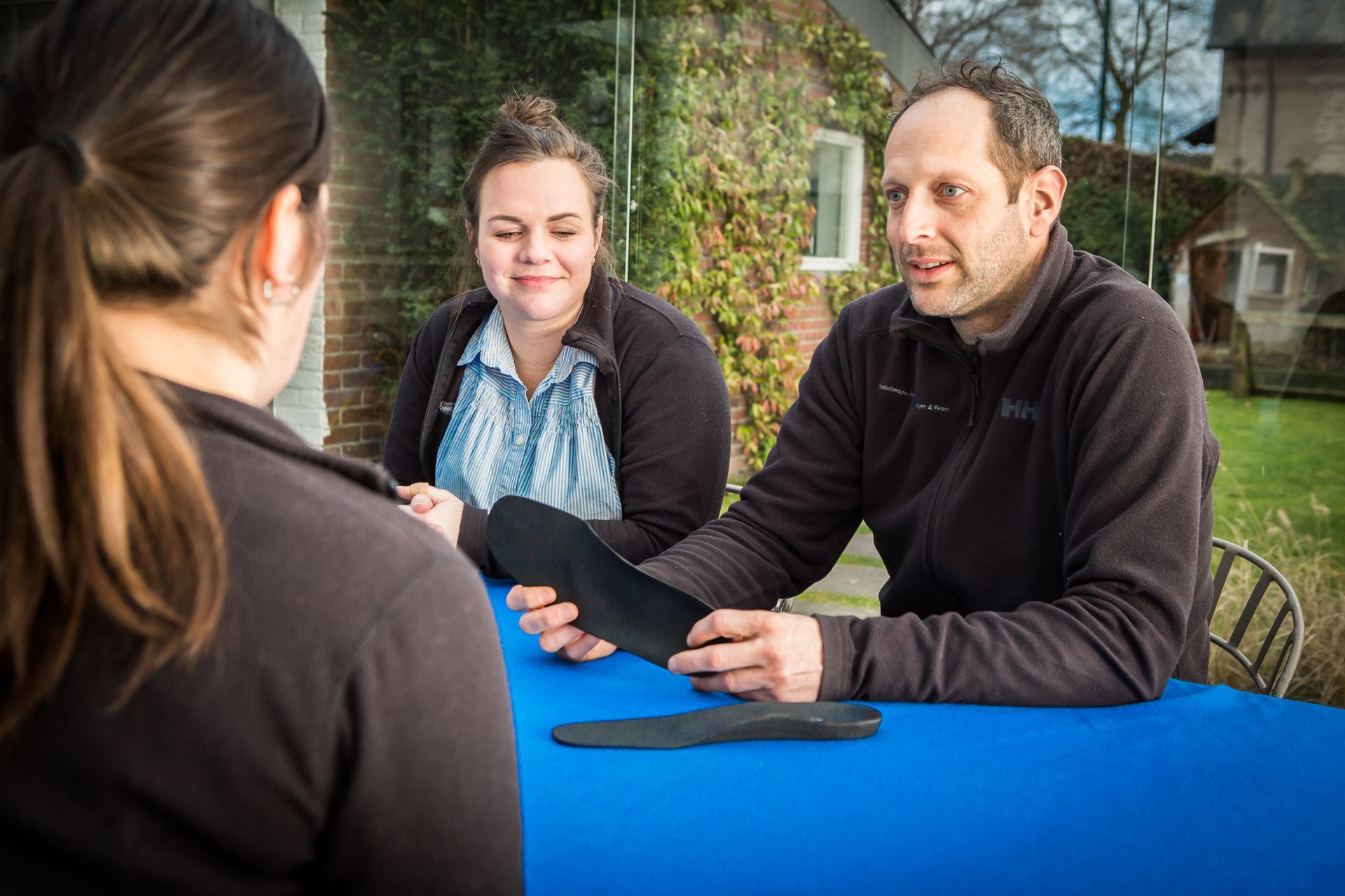 Een man en een vrouw zitten aan een tafel met elkaar te praten.