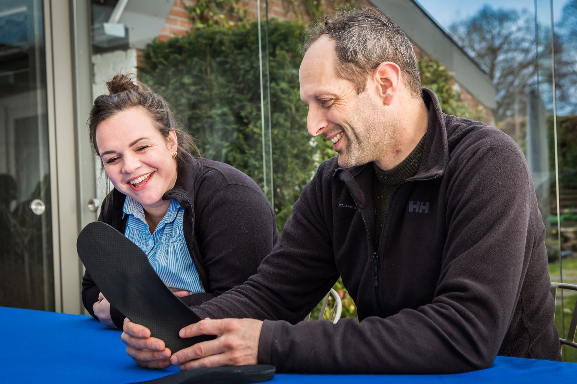 Een man en een vrouw zitten aan een tafel met elkaar te praten.
