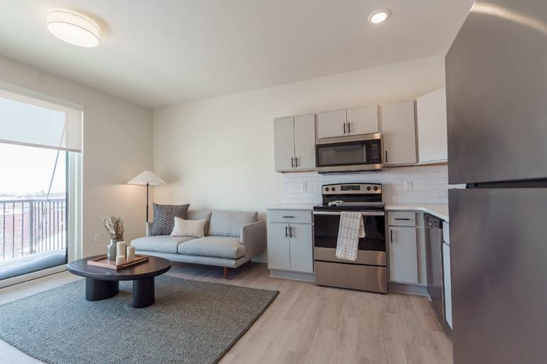 Photo of a living room that has a seamless open floor plan integrated with the kitchen