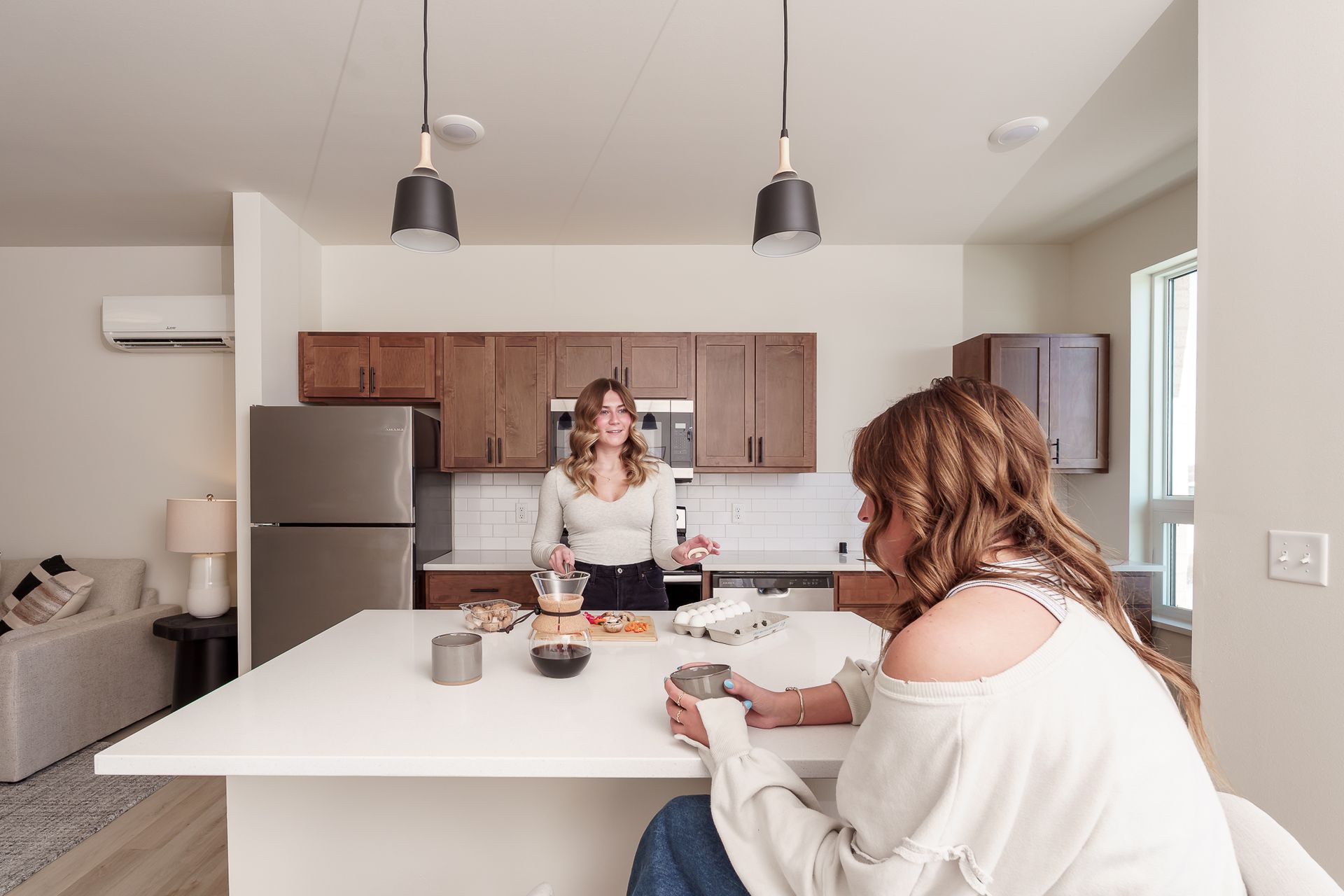 Photo showing two people at a countertop, one sitting and one standing on the other side