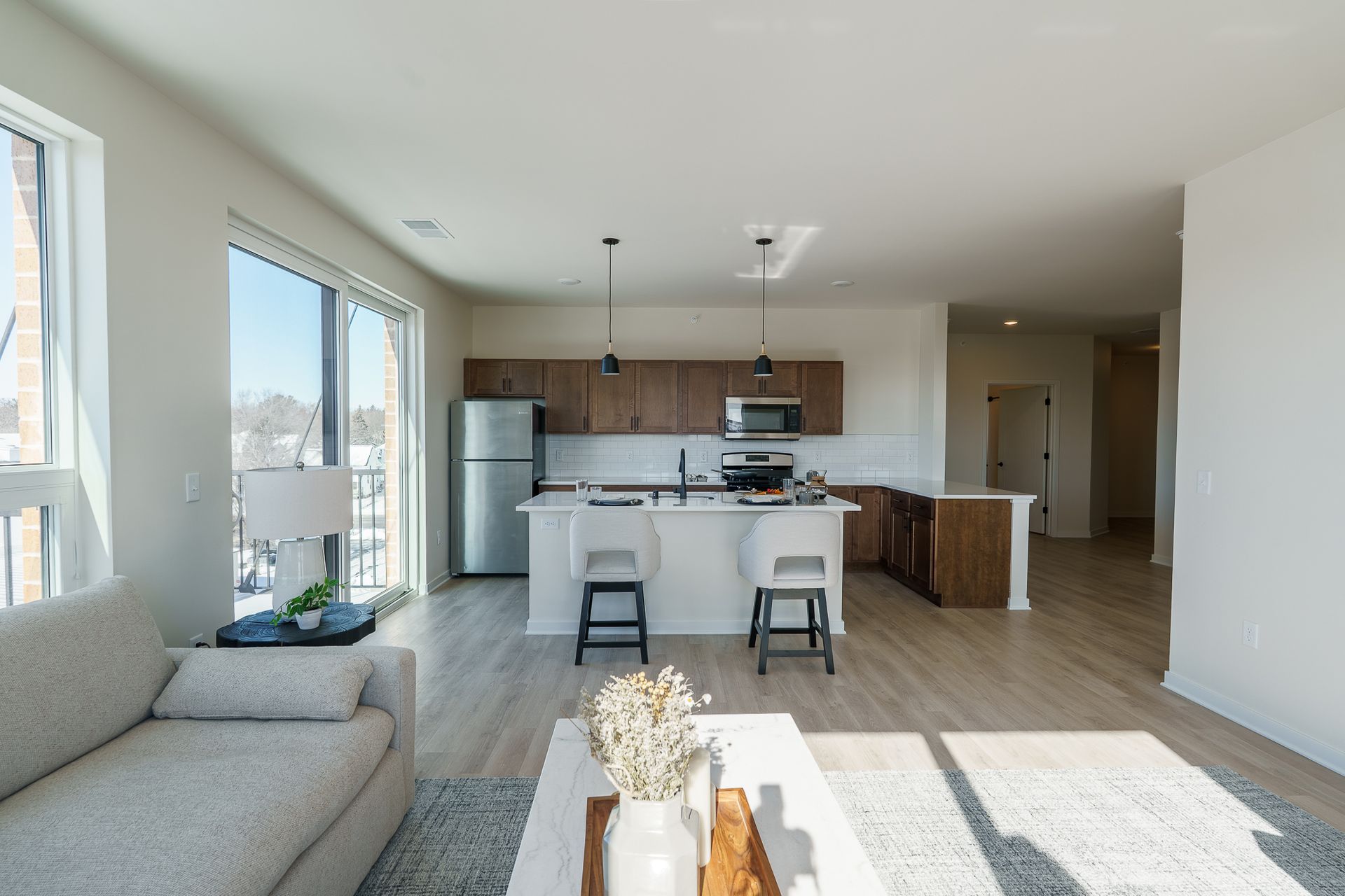 Photo of a living room with a kitchen in the background