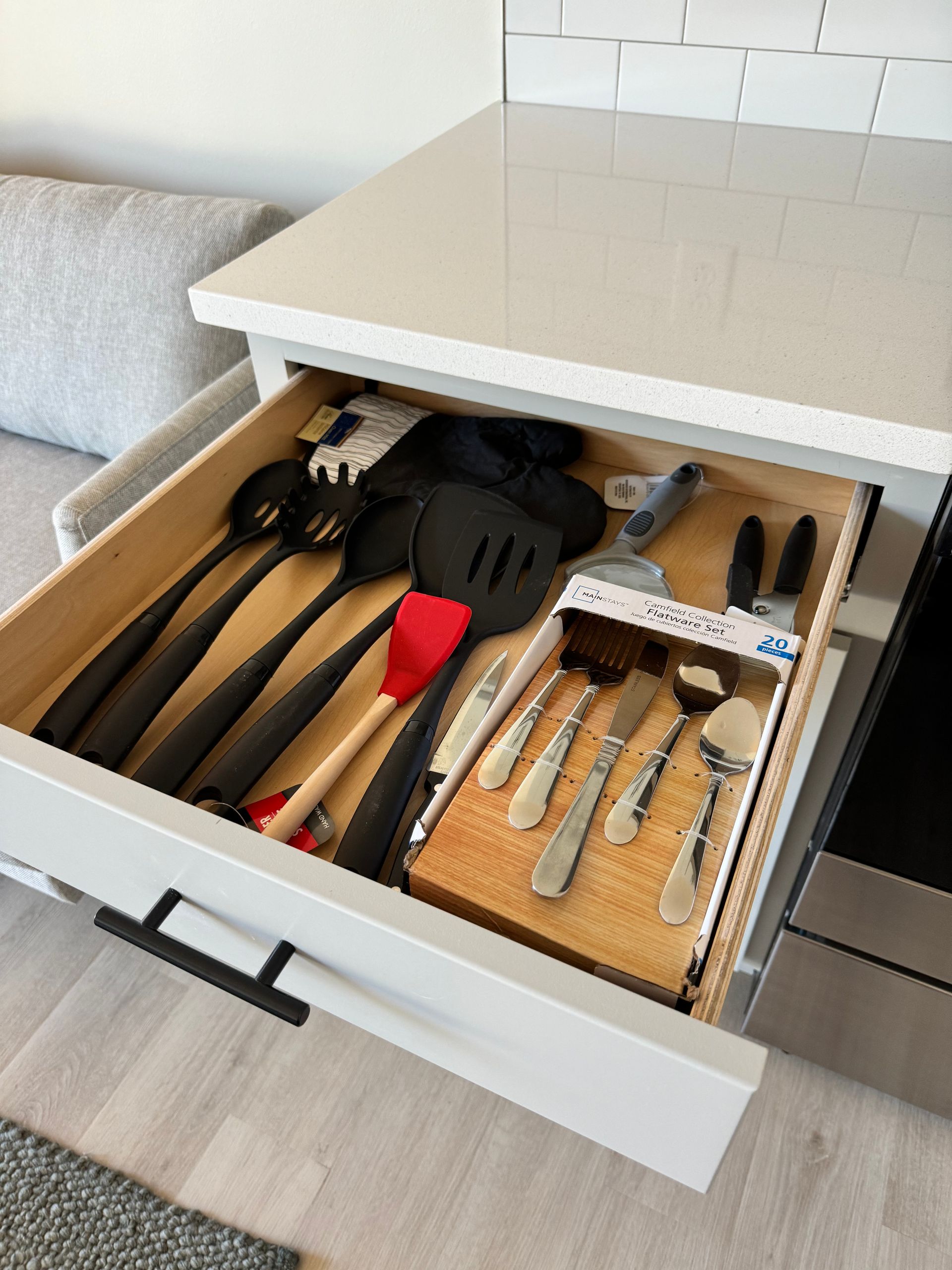 Photo of a drawer that is opened and has utensils inside