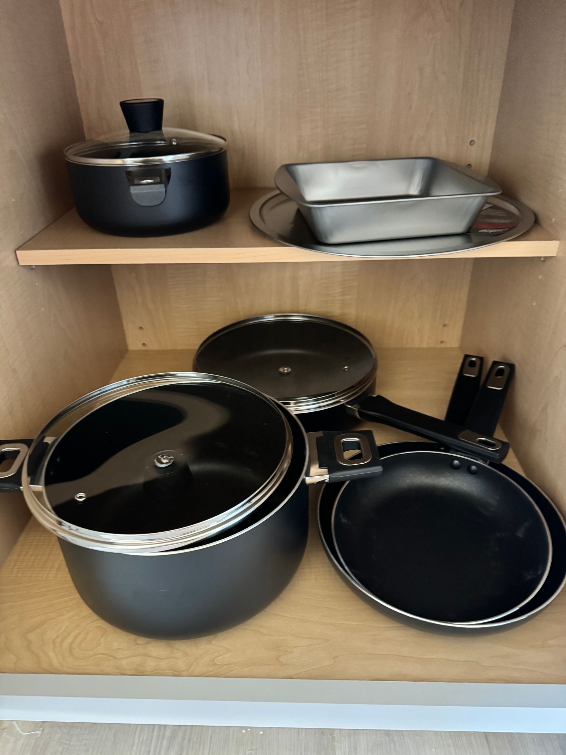 Photo of skillets and pots and pans in a cabinet
