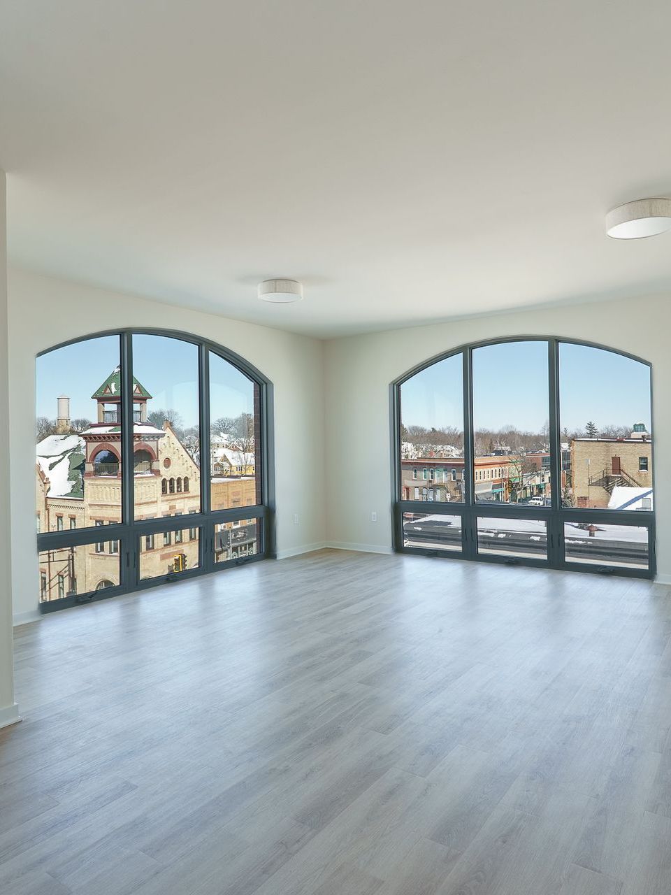 Photo of a large living room with massive, arch-shaped windows