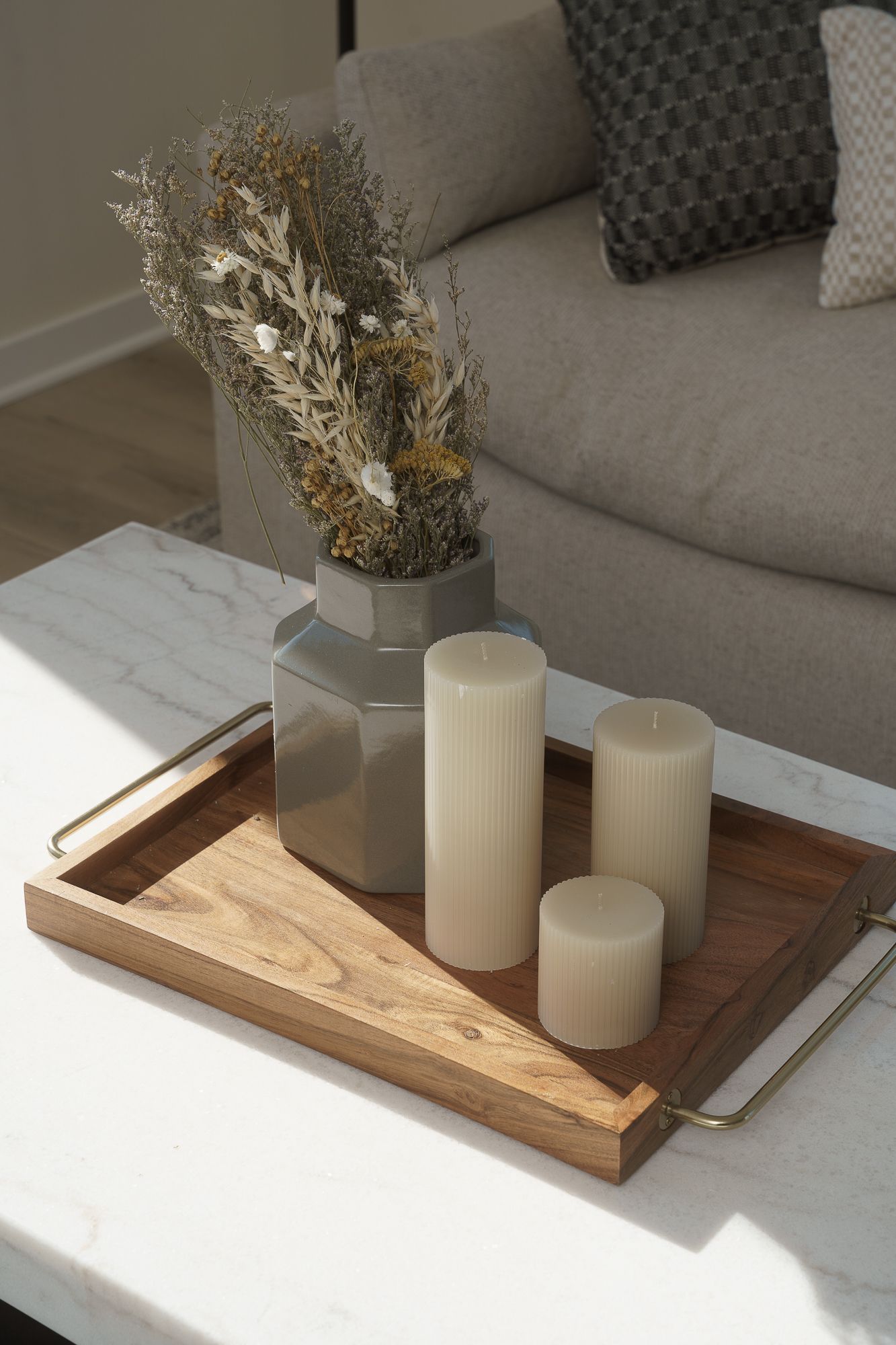 Photo of a table arrangement of candles and a pot with a floral arrangement