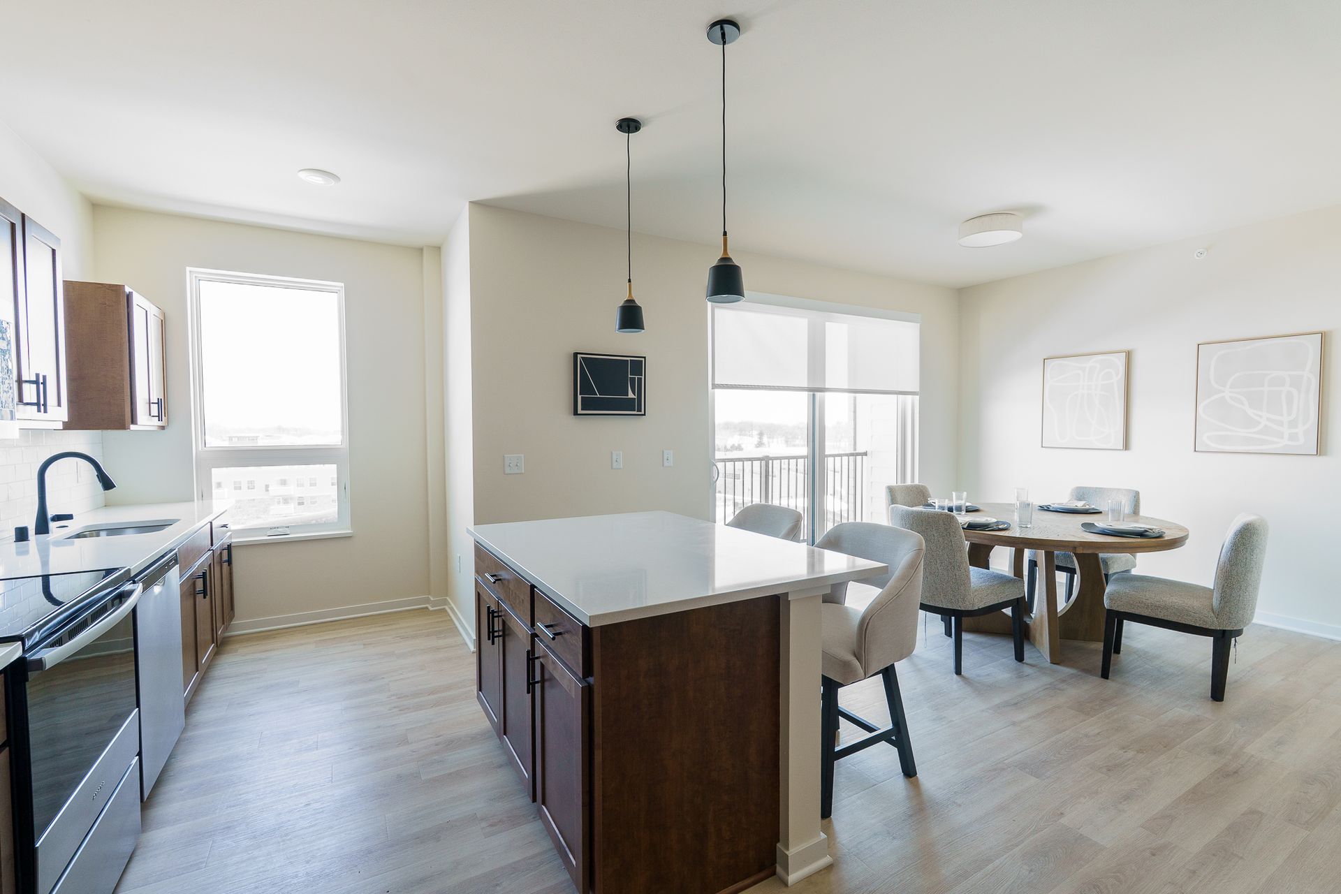 Photo of a kitchen in the foreground and a dining area in the background