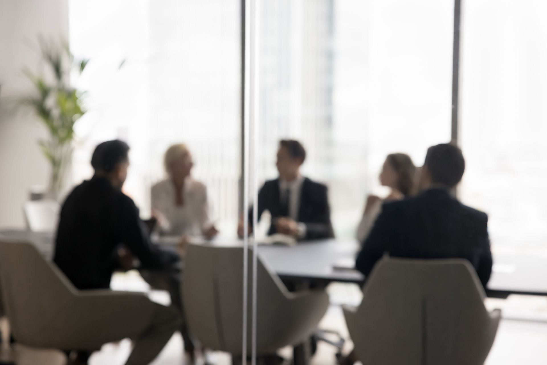 A group of people are sitting around a table in a conference room.