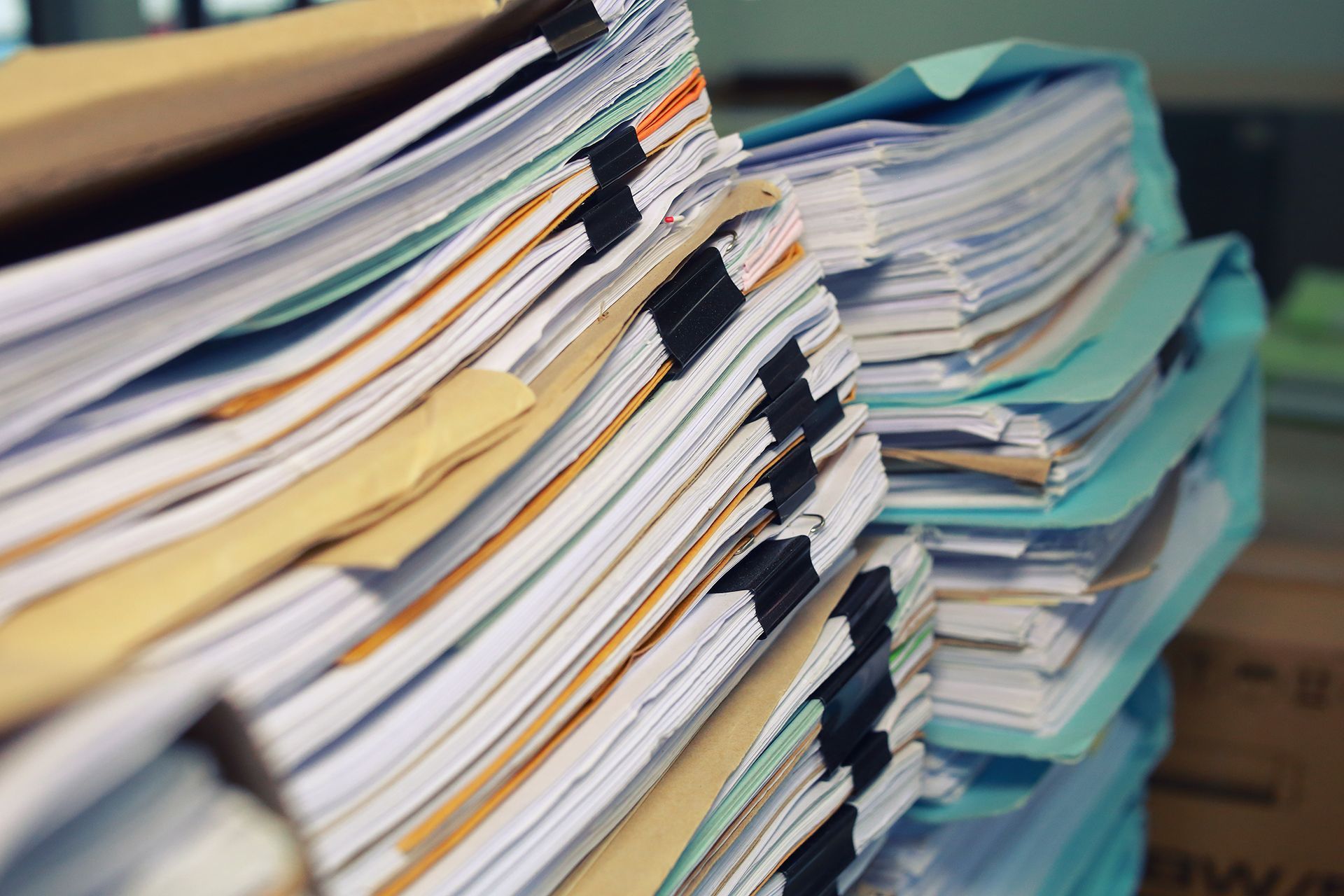 A pile of papers and folders stacked on top of each other.