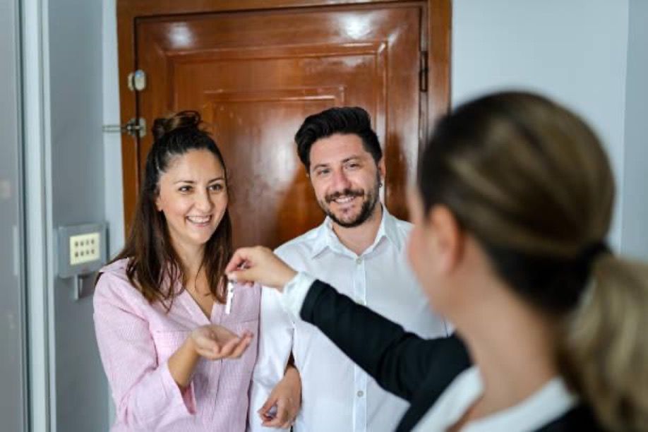 Couple getting house keys from a real estate agent.