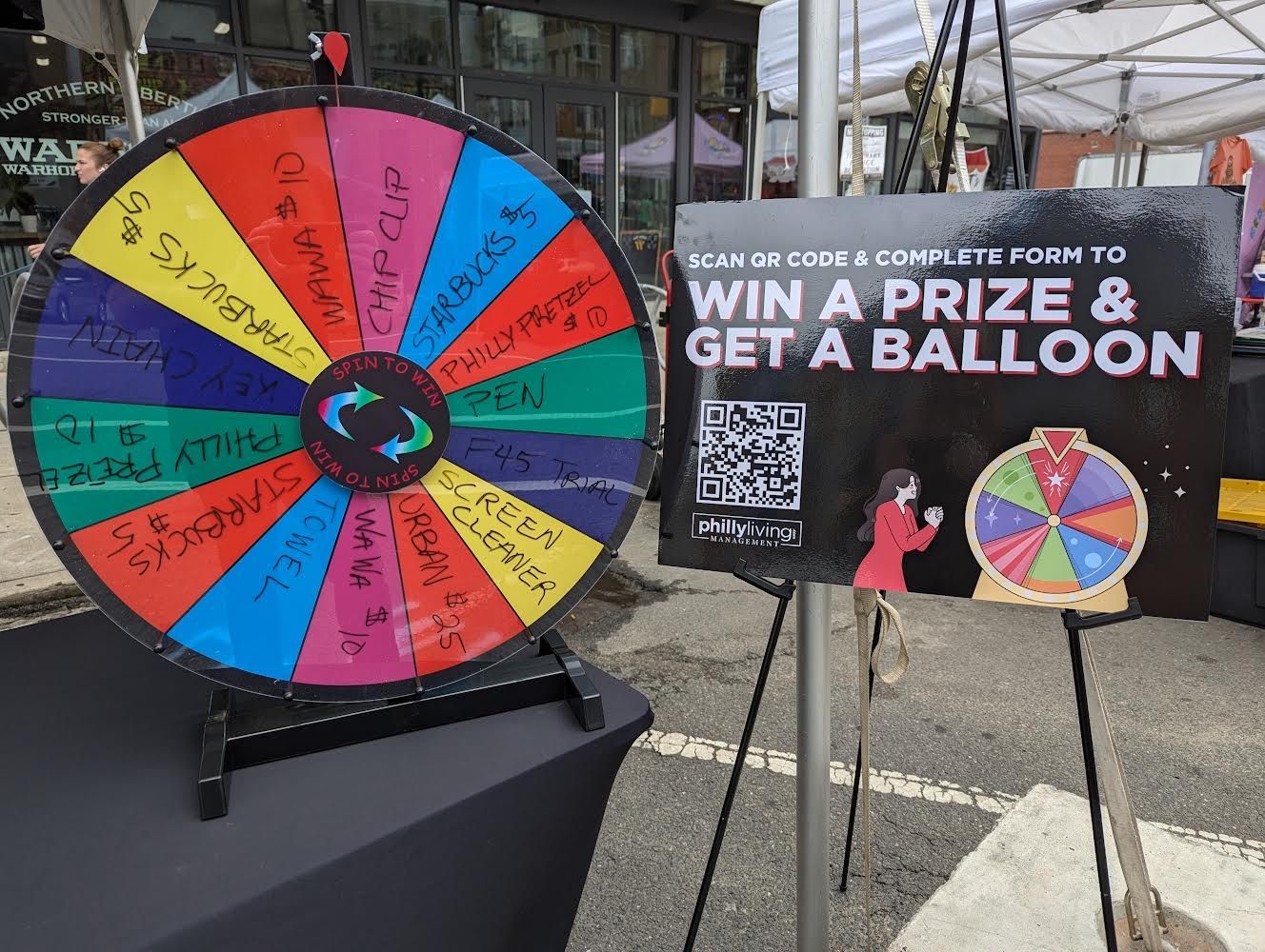 A colorful spinning wheel with a sign that says win a prize and get a balloon