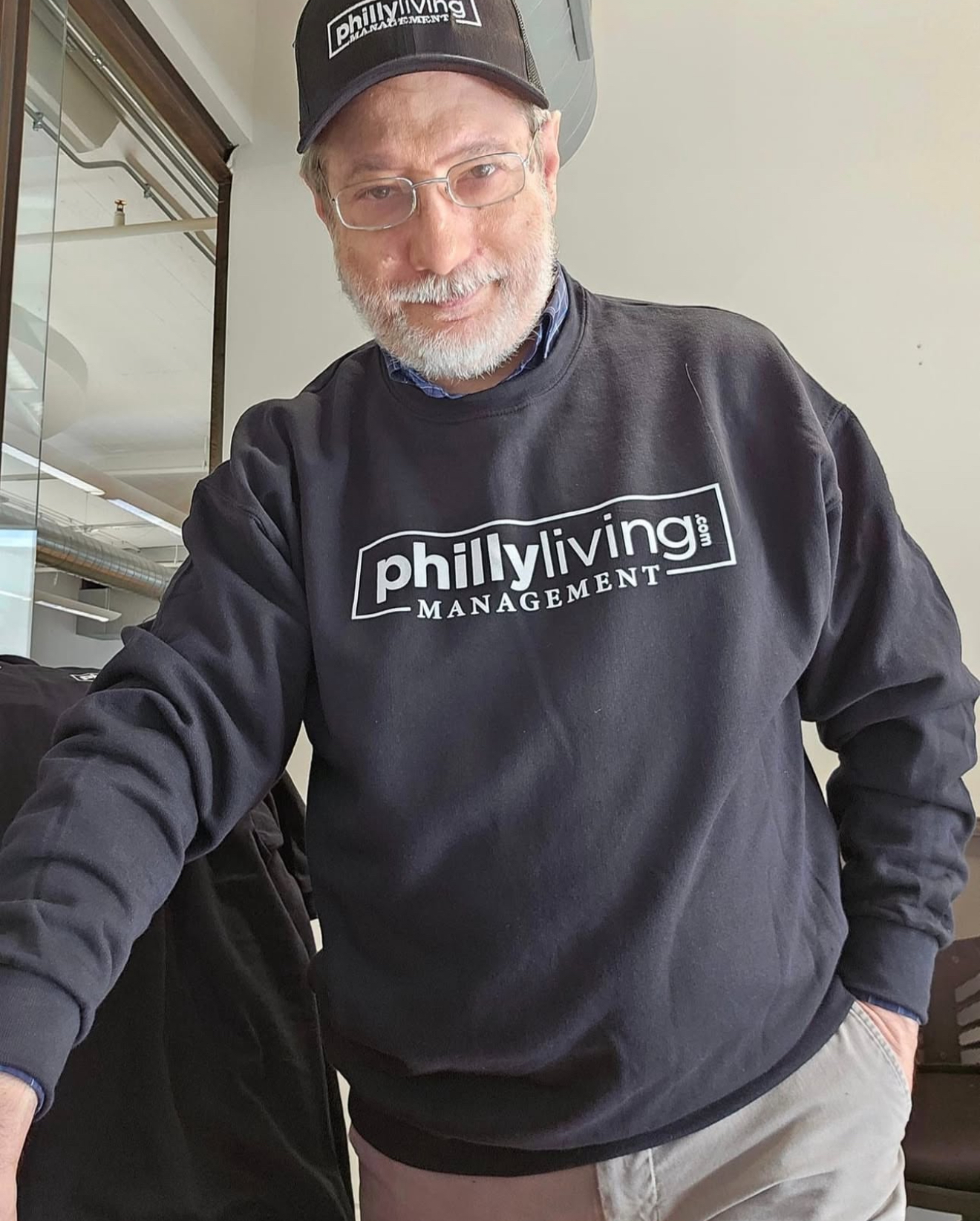 A man wearing a philly living management sweatshirt