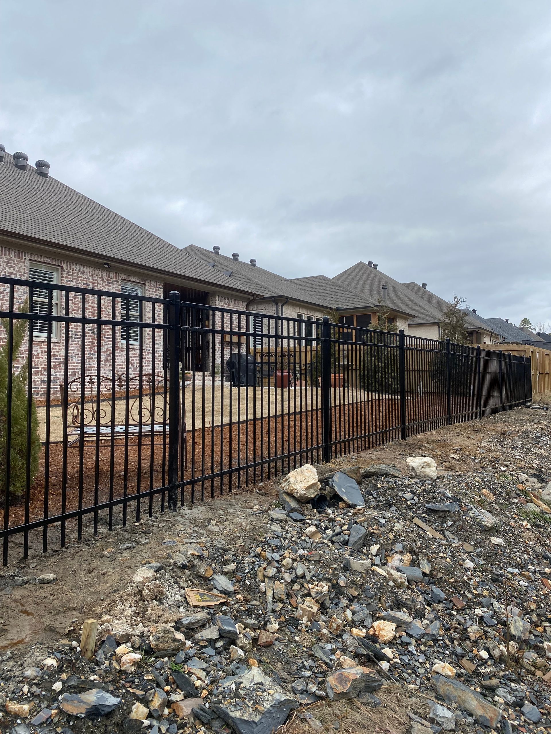 White picket fence on green lawn, under blue sky with clouds.