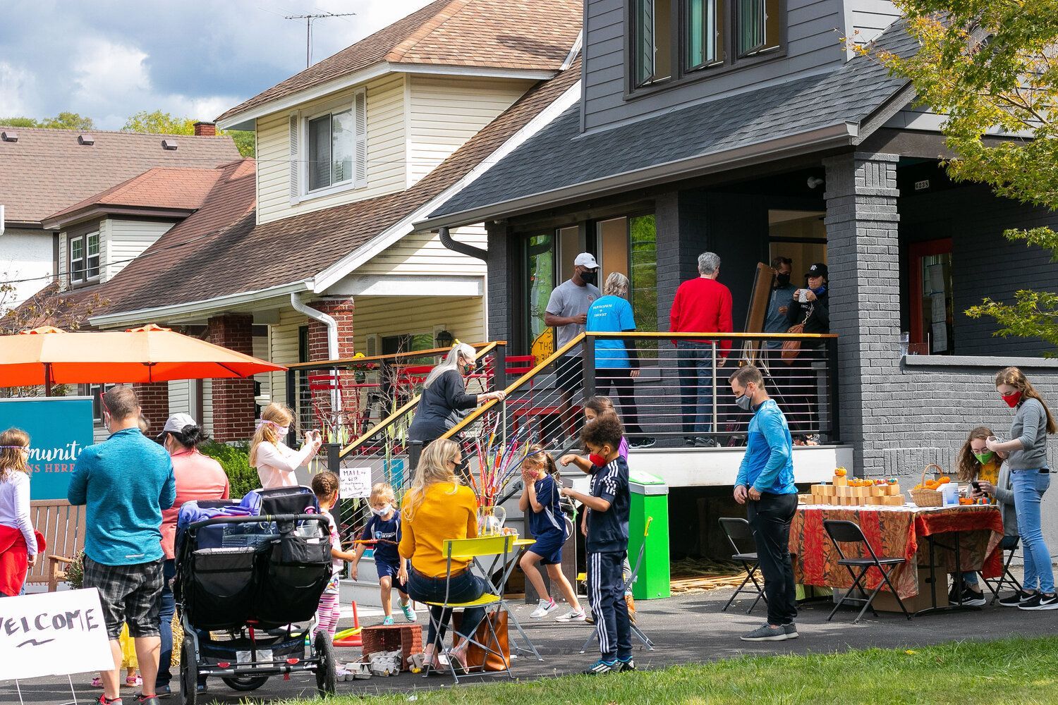 A group of people are standing outside of a house.