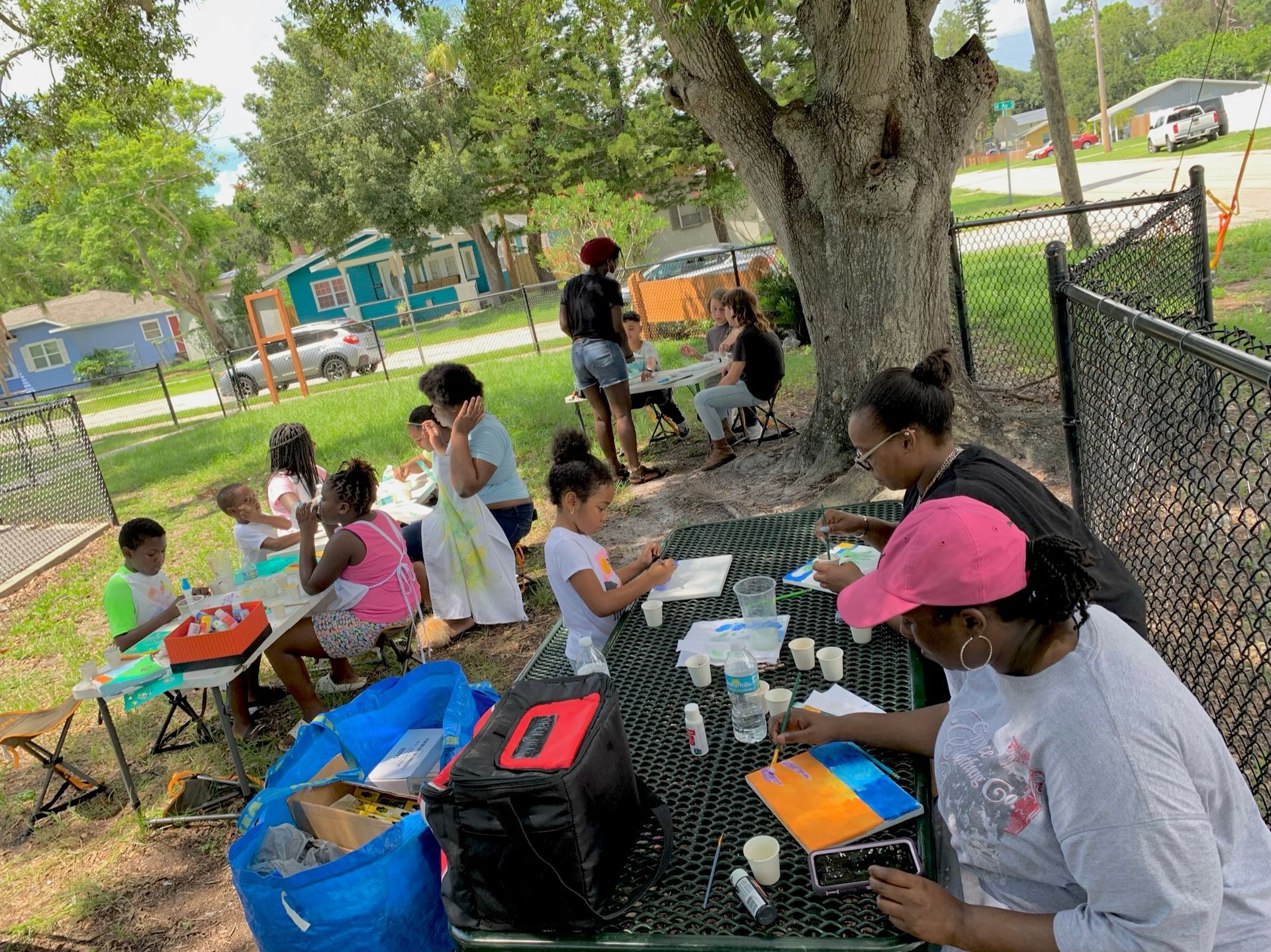 A group of people are sitting at a picnic table in a park.
