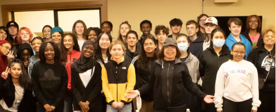 A large group of people are posing for a picture in a room.