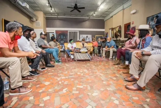 A group of people are sitting in a circle in a room.