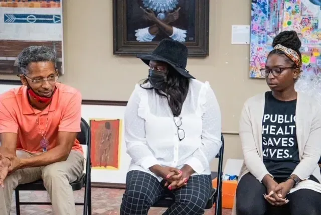 A group of people are sitting in chairs in a room.