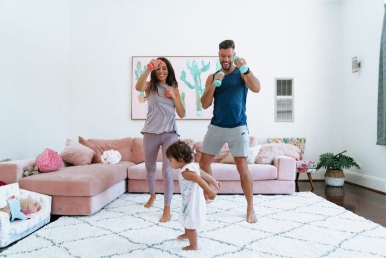 A Family is Dancing Together in a Living Room — New Horizons Dental in Port Douglas, QLD