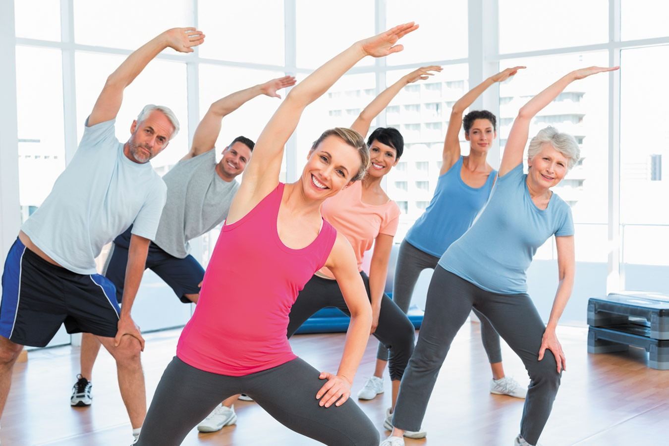 A Group of People Are Doing Stretching Exercises in a Gym — New Horizons Dental in Port Douglas, QLD
