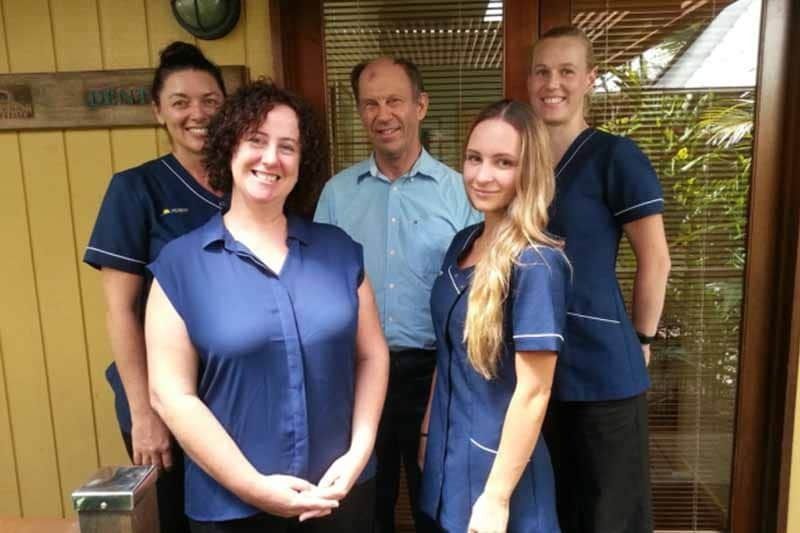 A Group of People in Blue Scrubs Are Posing for a Picture — New Horizons Dental in Port Douglas, QLD