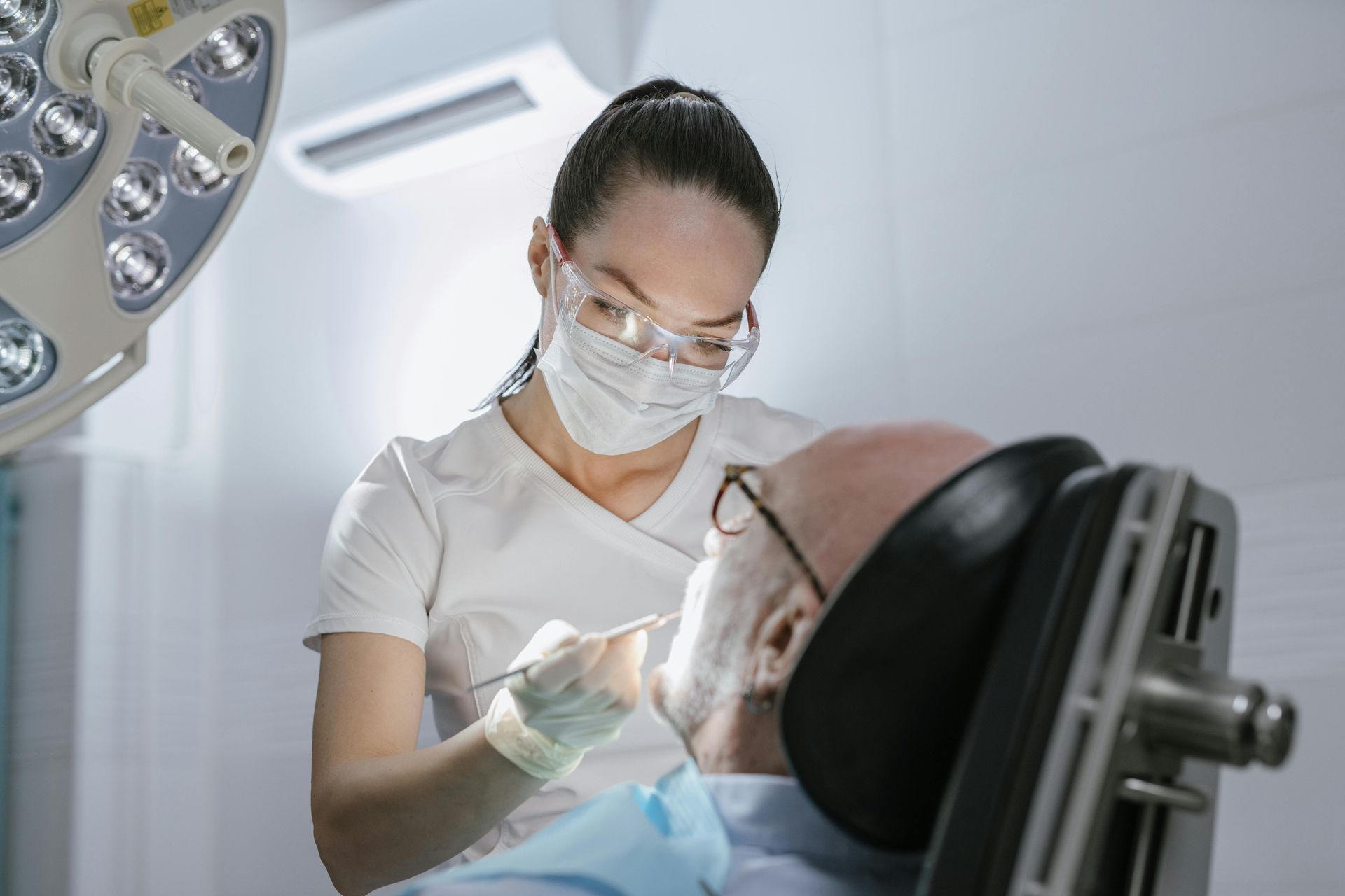 A Woman is Getting Her Teeth Examined by a Dentist — New Horizons Dental in Port Douglas, QLD
