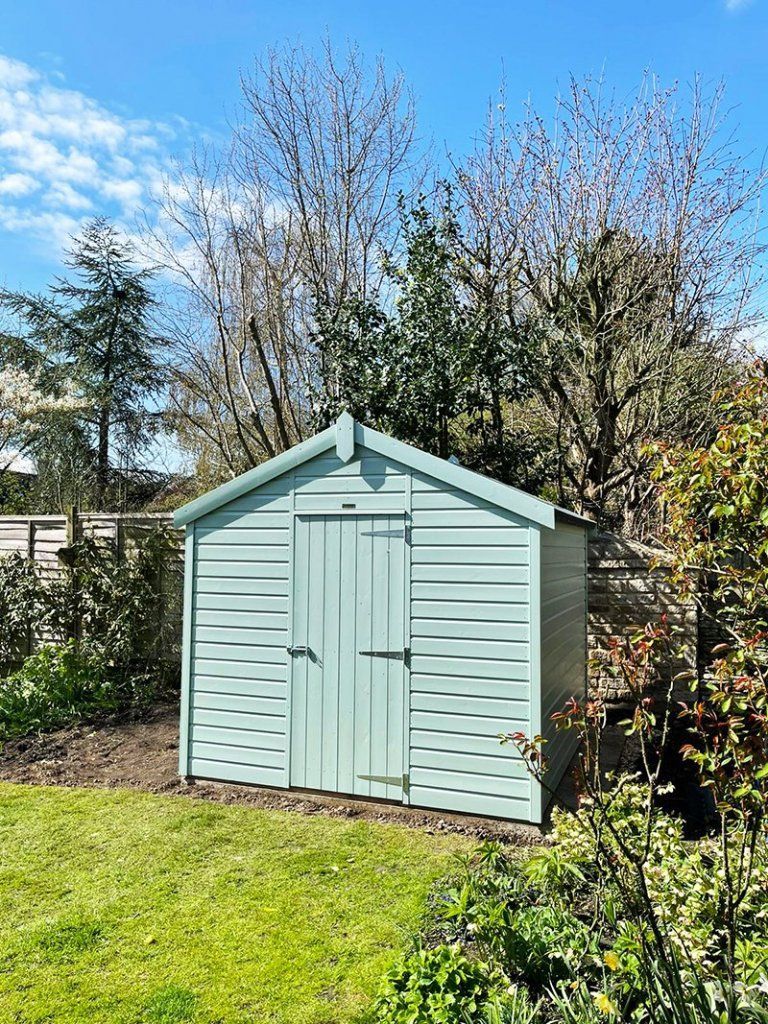 Light blue shed in a garden in Preston, UK. Expertly painted by Rose Decor.