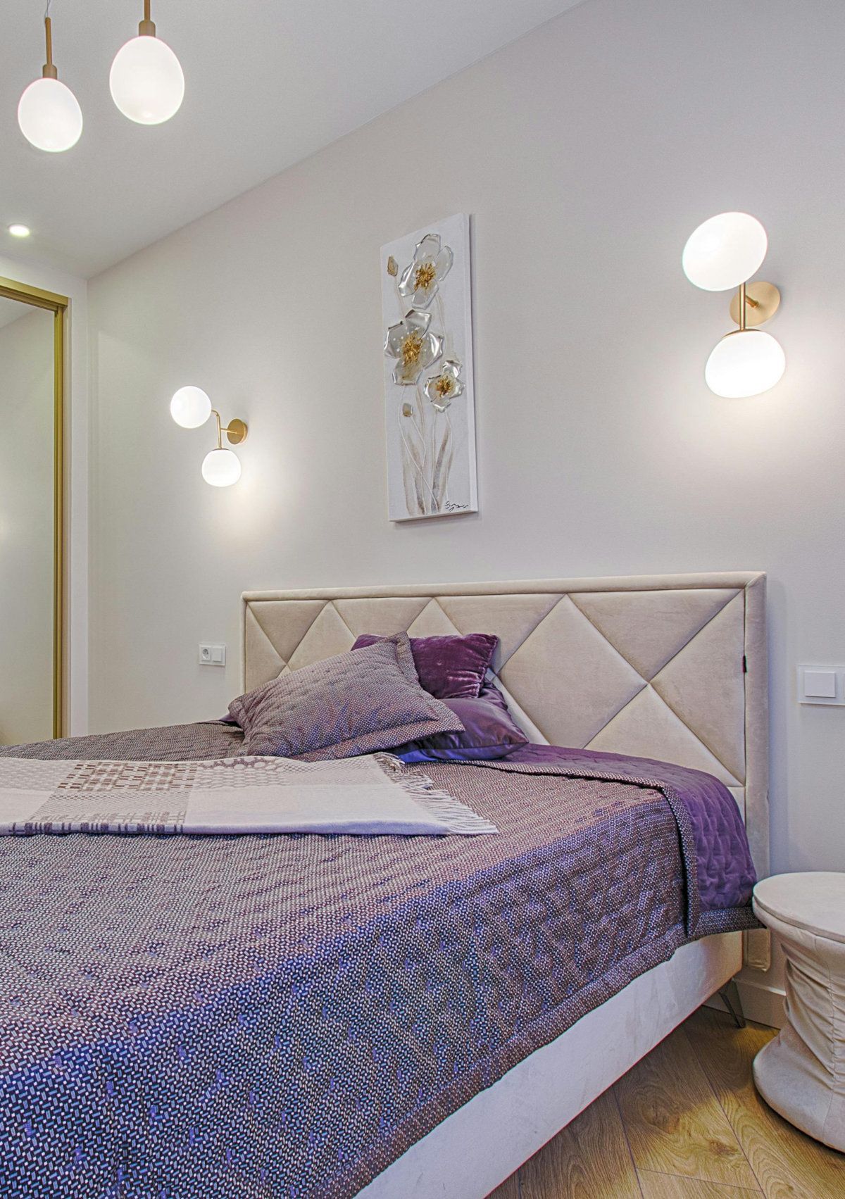 A bedroom with a bed , nightstand , and painting on the wall.