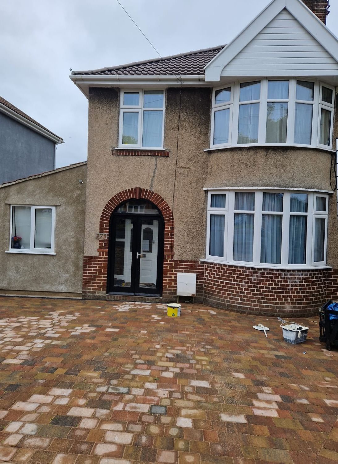 A large house with a brick driveway in front of it