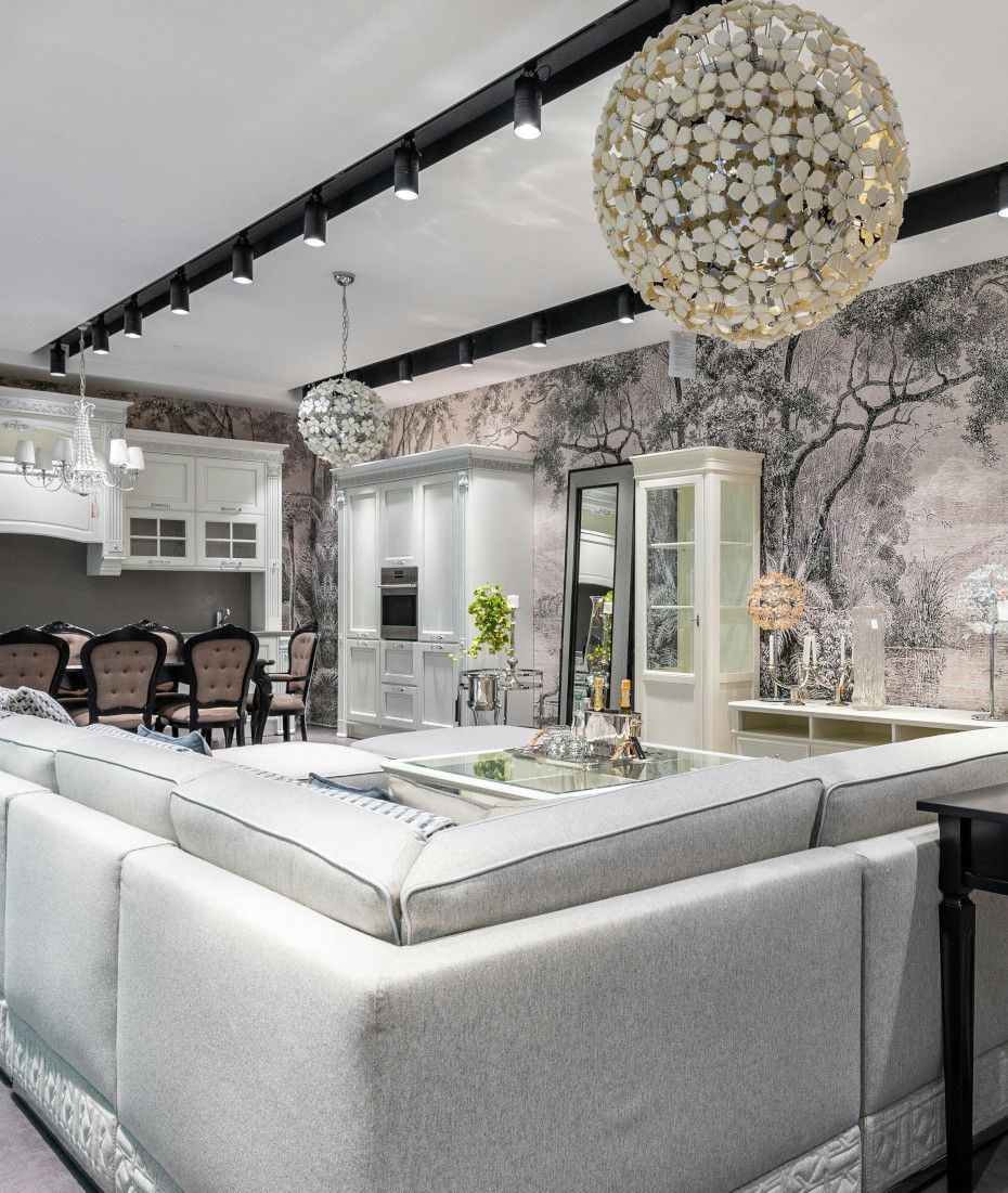 A living room with a large couch and a chandelier hanging from the ceiling.