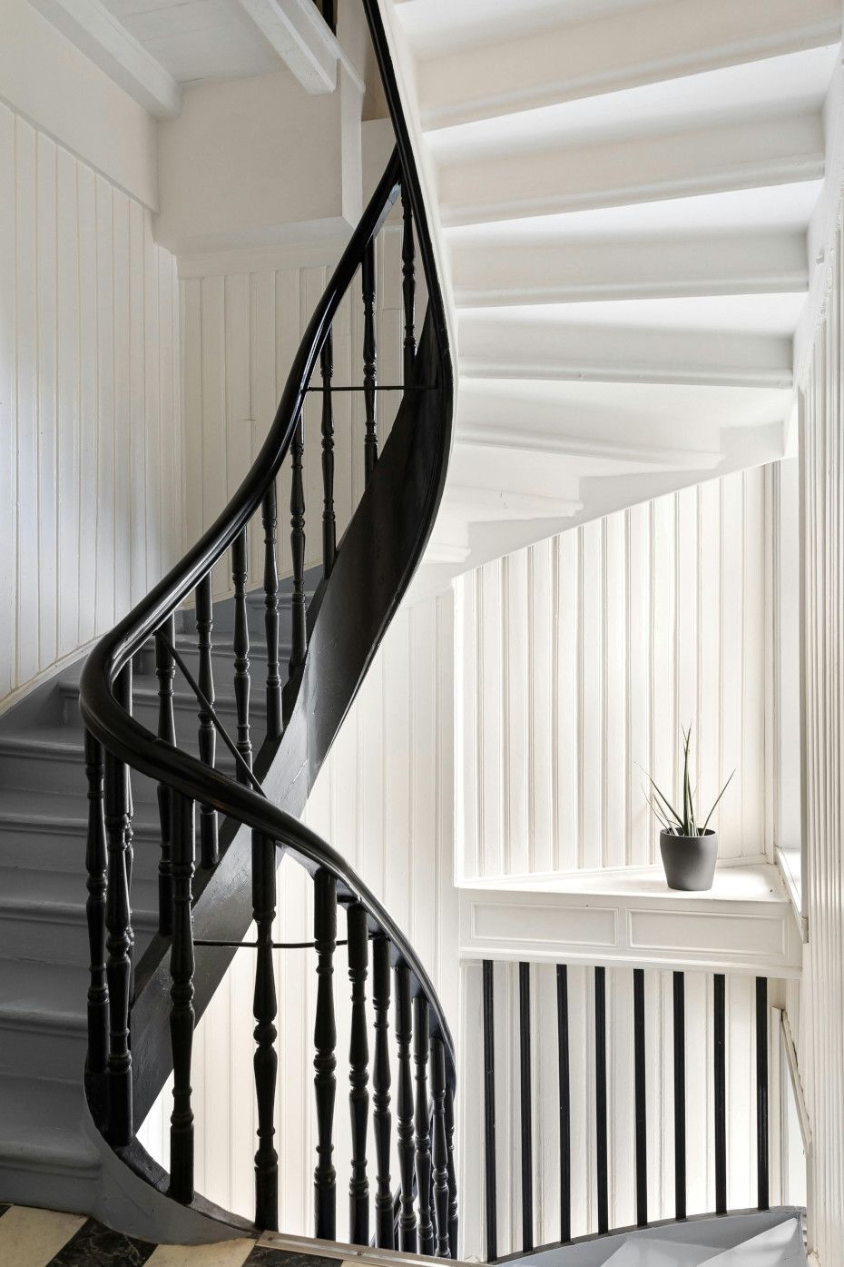 A black and white spiral staircase with a black railing