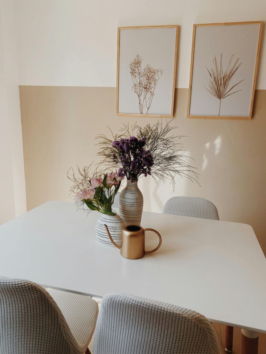 Dining area with wooden table and chairs near a bright window.
