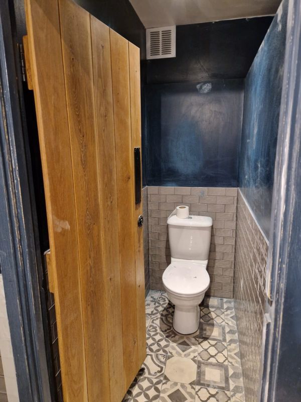 A bathroom with a toilet and a wooden door