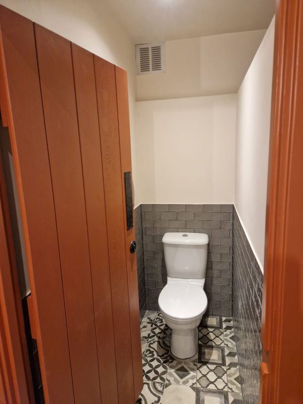 A bathroom with a toilet and a wooden door