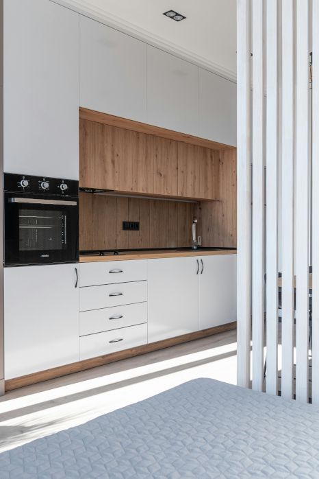 A kitchen with white cabinets and wooden counter tops