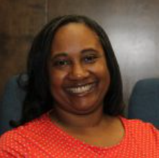 Woman with a warm smile wearing a red polka-dotted shirt.
