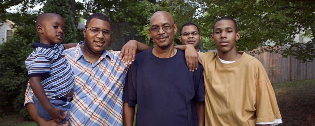 A group of five people standing outside, smiling.