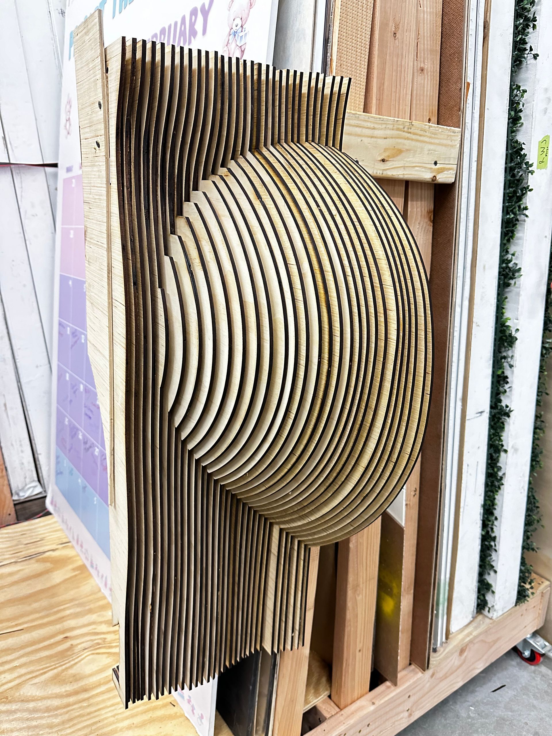 A wooden sculpture of a sphere is sitting on top of a wooden pallet.